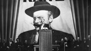 Charles Foster Kane (Orson Welles) makes a stirring campaign speech before a larger-than-life portrait of himself in a scene from Citizen Kane. Image: Getty/TNW