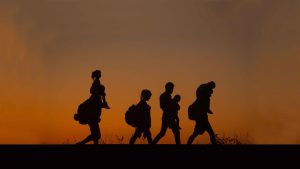 Asylum seekers walk along a railway line   close to the village of Roszke in Hungary. Image: Matt Cardy/Getty