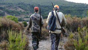 Hunters walk with their rifles before the start of a wild boar hunt in Cognocoli-Monticchu, on the French Mediterranean island of Corsica on August 21, 2021. Photo: PASCAL POCHARD-CASABIANCA/AFP via Getty Images