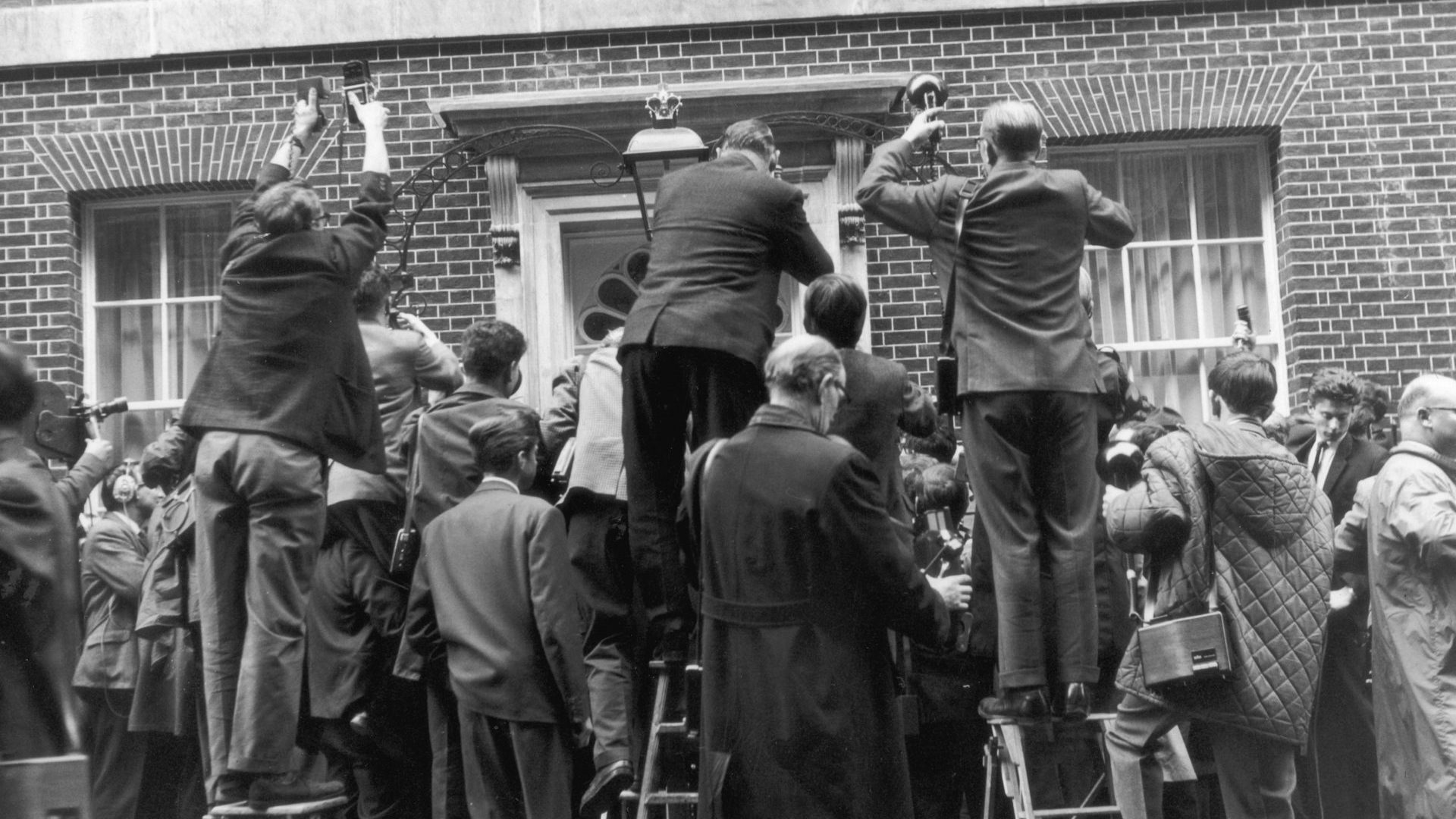 Photographers jostle for position outside 10 Downing Street as Sir Alec Douglas-Home arrives to take up residence as Britain’s new prime minister, October 1963. 
Image: Moore/Fox Photos/Hulton Archive/Getty

