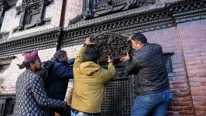 Locals attach the historic toran to its original place above the right-side window of the main entrance of Kumari House in Kathmandu. Photo: Safal Prakash Shrestha/NurPhoto via Getty Images