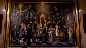 a Steward (junior lodge officer) walks past a large symbolic painting inside Freemasons’ Hall. They assist with ceremonies and the running of meetings, supporting senior members within the lodge. Image: Harry James Relf
