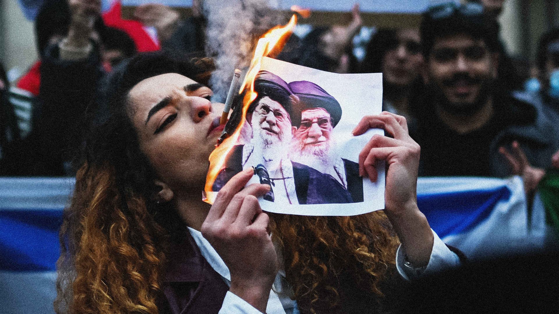 An anti-Iranian regime protester lights a cigarette with a burning paper depicting Iran’s supreme leader Ali Khamenei during a gathering outside the US Consulate in Milan on January 13, 2026. Image: by Piero Cruciatti/AFP via Getty Images