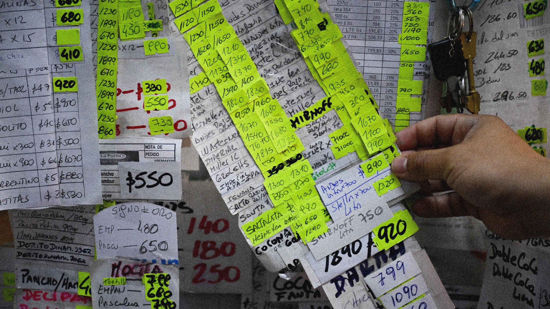 A worker holds a price list of products with labels modifying the price changes at a supermarket in Moron, Buenos Aires province, Argentina on November 22, 2023. Image: Luis Robayo/AFP via Getty 