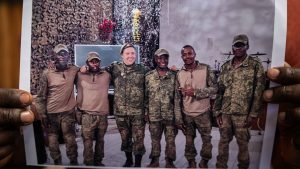 Evans Khagola, Oscars's cousin, holds a printed photo that shows (From left to right) three unknown soldiers, Wesley Lugadiru, whose whereabouts is unknown, Evans Sabuni, identified in the picture by friends and former colleagues, and Oscar Khagola (far right), to be photographed on January 21st 2026, in Nairobi, Kenya. Photo: Ed Ram/For The Washington Post via Getty Images