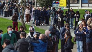 Staff and students, some wearing face masks, queue to receive antibiotics at the University of Kent in Canterbury after an outbreak of meningitis caused the deaths of two people. Image: Carl Court/Getty