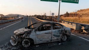 A view of a burned car, allegedly set on fire by organised crime groups in response to an operation to arrest a high-priority security target, on a highway near Acatlan de Juarez, Jalisco state. Photo: Ulises Ruiz / AFP via Getty Images