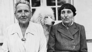 Gertrude Stein, left, poses with Alice B Toklas, and her dog, Basket, in front of her home in France in 1944. Image: Bettmann/Getty