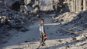 A boy in the rubble of Gaza City. IMAGES: OMAR AL-QATTAA; BASHAR TALEB/ AFP/GETTY