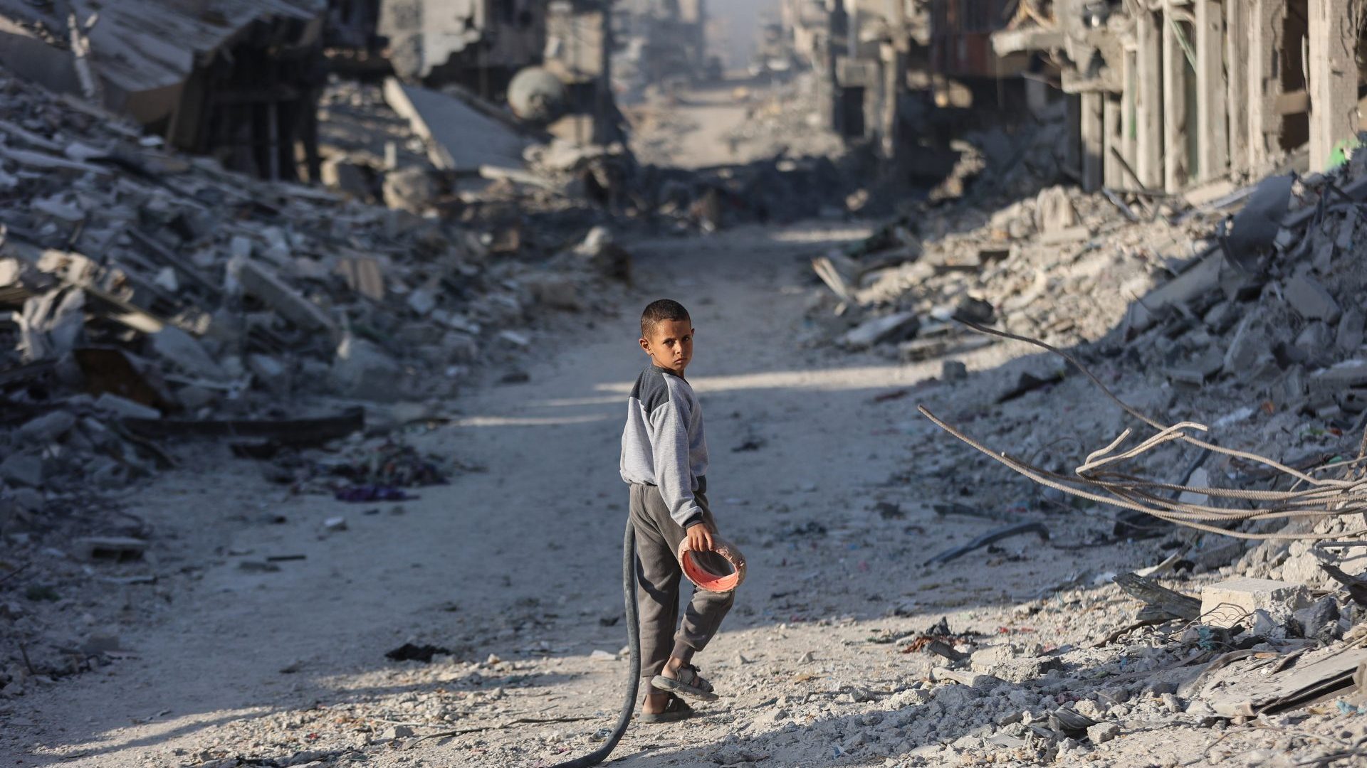 A boy in the rubble of Gaza City. IMAGES: OMAR AL-QATTAA; BASHAR TALEB/ AFP/GETTY