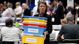 A woman carries boxes for ballot papers as the count for the Penistone West ward goes to a second recount during the local election count. Photo: Anthony Devlin/Getty Images