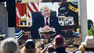 Attendees watch a pre-recorded video of Donald Trump reading from the Bible during Rededicate 250. Photo: Matthew Hatcher / AFP via Getty Images
