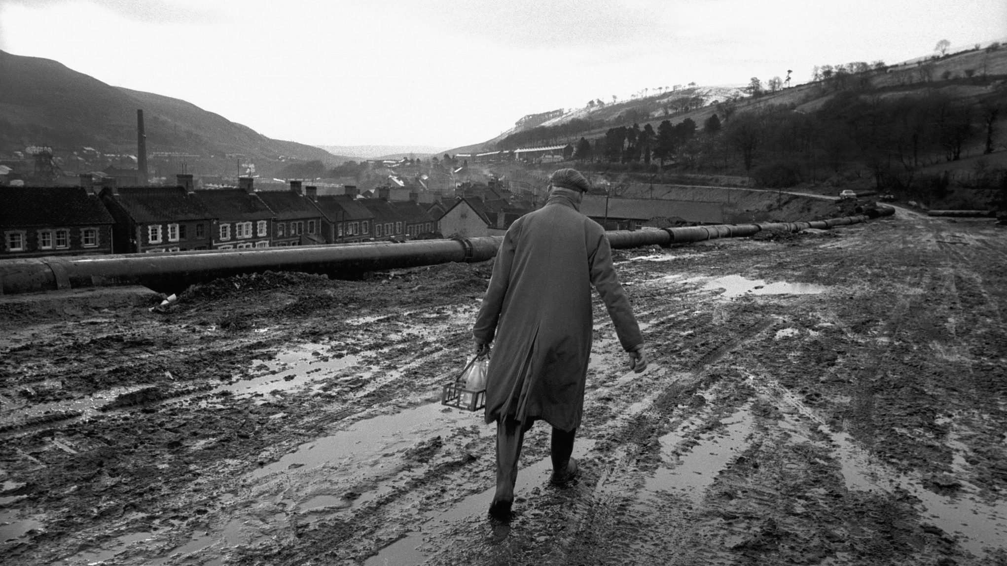 A man carrying empty milk bottles walks down a road in November, 1966 in the mining town of Aberfan, South Wales. Photo: I.C. Rapoport/Getty Images