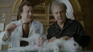 Ross Hatt as Dr. Berg, Tom Cruise as Rockwell with Maggie the cat in Digger. Credit: Warner Bros. Pictures